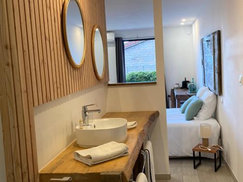 a bathroom with a sink and a bed and a mirror at Casa Santa Giulia in Propriano