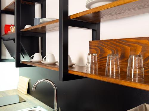 un bancone della cucina con bicchieri su una mensola in legno di Golubina 2 - Studio Apartman a Golubac