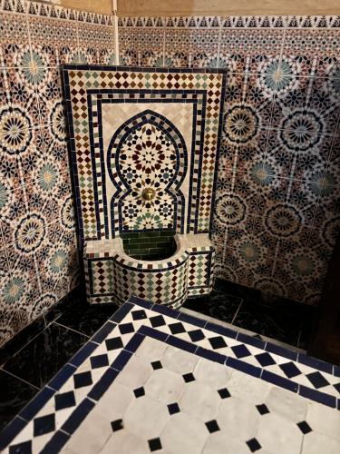 een badkamer met een tegelwand met een Marokkaanse kus bij Riad khoya magnifique in Marrakesh