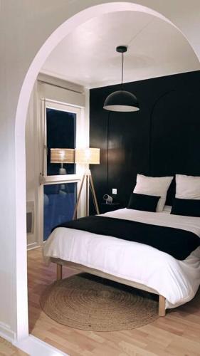 a bedroom with a large bed with a black wall at Appartement vue sur mer in Plérin