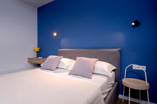 a blue bedroom with a bed with white pillows at Modern, 2 bedroom apartment in Hvar
