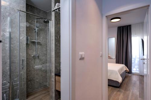 a bathroom with a shower and a bed in a room at Modern, 2 bedroom apartment in Hvar