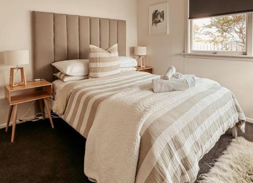 a bedroom with a large bed and a window at Beachfront Retreat On Revell in Hokitika
