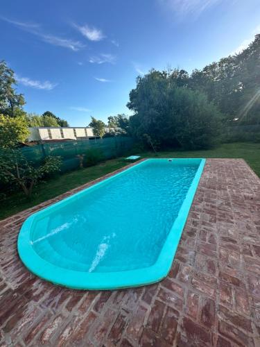 uma grande piscina azul num pátio de tijolos em A CAZON QUITADO em Saladillo