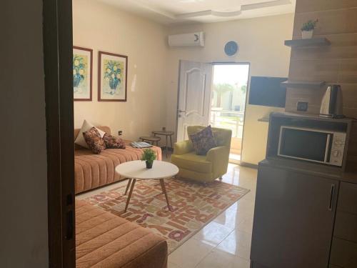 een woonkamer met een bank, een tafel en een tv bij Claire de lune in Nouakchott