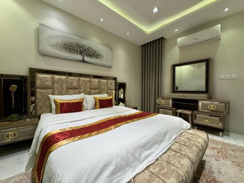una grande camera da letto con un letto grande e una televisione di شقة فاخرة غرفتين وصالة النرجس ١٥ a Riyad