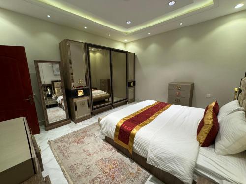 une chambre avec un grand lit et un miroir dans l'établissement شقة فاخرة غرفتين وصالة النرجس ١٥, à Riyad