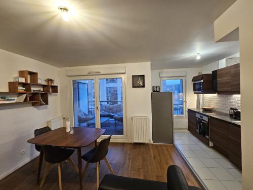 a kitchen and living room with a table and chairs at Cosy Furnished Studio Near Paris and Stade de France in Saint-Ouen