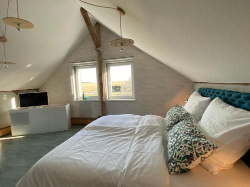 a bedroom with a white bed and a television at Ferienhaus Lotte Havelland in Götz