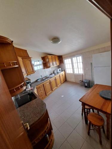 a kitchen with wooden cabinets and a table and a refrigerator at Betty House. in Santa Cruz