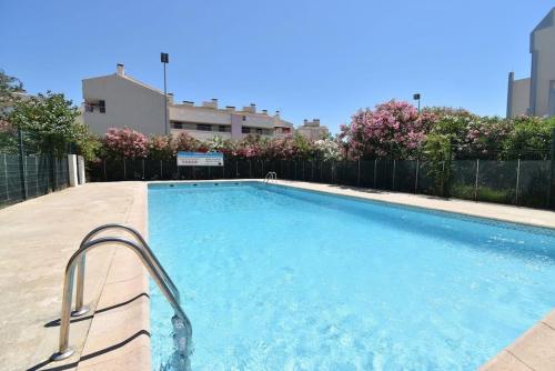 une grande piscine avec une clôture métallique dans l'établissement *La Brise Marine*Piscine*Parking*Clim*, au Grau-du-Roi