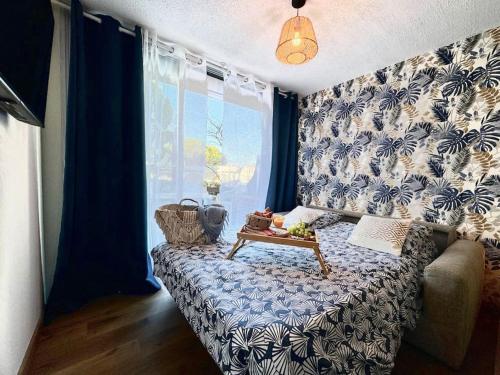 - une chambre avec un lit aux motifs bleu et blanc dans l'établissement *La Brise Marine*Piscine*Parking*Clim*, au Grau-du-Roi