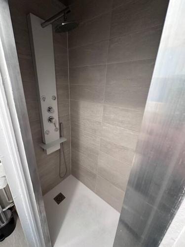 une douche avec un rideau de douche dans une salle de bain dans l'établissement L’insolite, à Auxerre