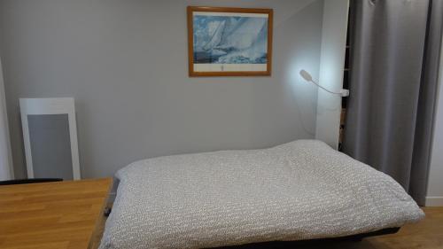 1 dormitorio con 1 cama y una foto en la pared en Le Petit Malo - Sudio avec terrasse et parking privé, en La Rochelle