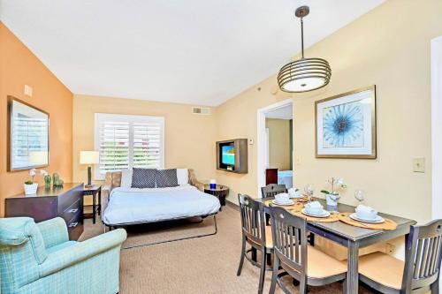 a living room with a bed and a dining room at Condo Near Universal Studios With Pool Hot Tub in Orlando