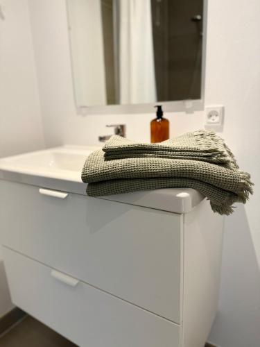 La salle de bains blanche est pourvue d'un lavabo et d'un miroir. dans l'établissement Charmerende bolig nær Domkirken, à Ribe