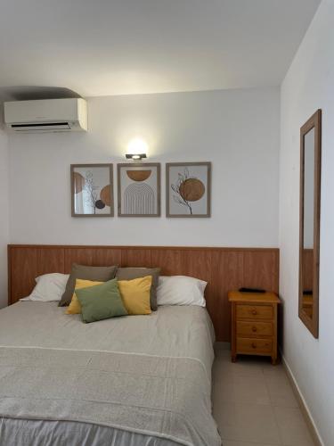 een slaapkamer met een bed en een houten hoofdeinde bij Preciosa casa con piscina de agua salada y aire acondicionado in Llança
