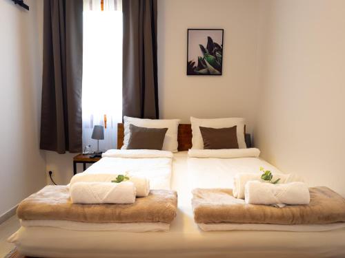 a bedroom with two beds with white sheets and furry pillows at Golubina 3 - Soba sa Sopstvenim Kupatilom in Golubac