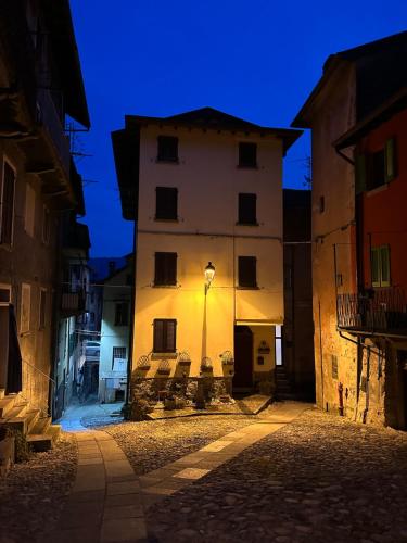 a building with a light on the side of it at night at La casa sulla collina - apt. 2 in Colonno