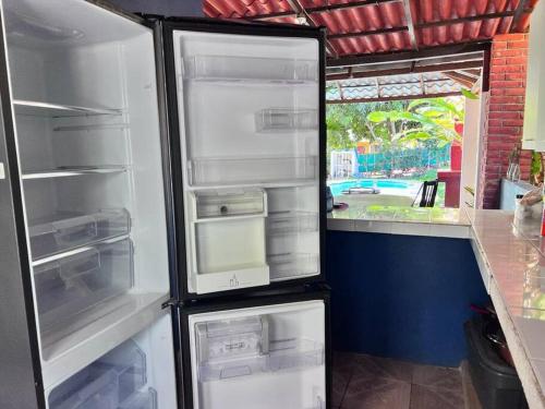 - un réfrigérateur avec une porte ouverte dans la cuisine dans l'établissement Casa en Condominios San Blas 5 minutos del Tunco, à La Libertad