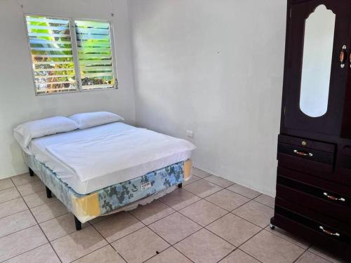 a small bedroom with a bed and a dresser at Casa en Condominios San Blas 5 minutos del Tunco in La Libertad