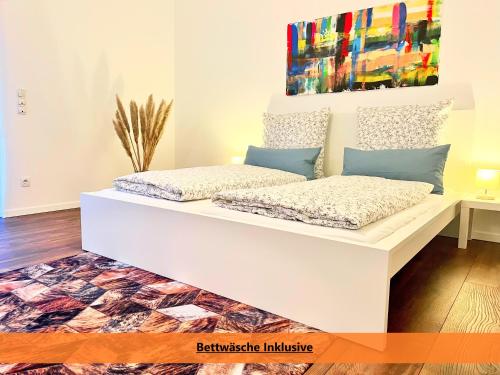 two beds in a room with a painting on the wall at Better Living - Villa - Exklusiv Studio 76qm in Montabaur