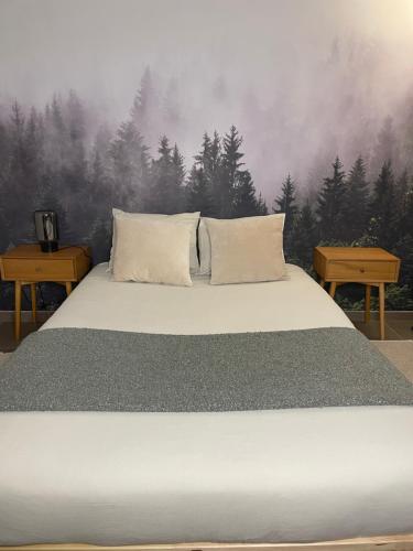 łóżko w sypialni z malowidłem leśnym w obiekcie La Canopée des Arbres, Anna w mieście Ellezelles