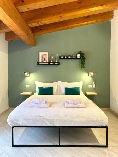 a bedroom with a large white bed with wooden ceilings at 4Rooms in Palermo