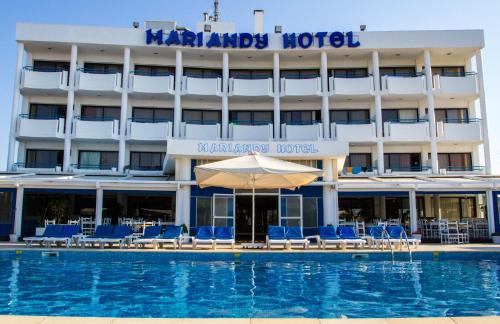 a hotel with a swimming pool with chairs and an umbrella at Mariandy Hotel in Larnaka