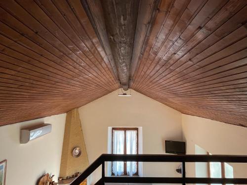 a room with a wooden ceiling and a window at Breva, Loft tra gli ulivi ed il lago in Bellagio