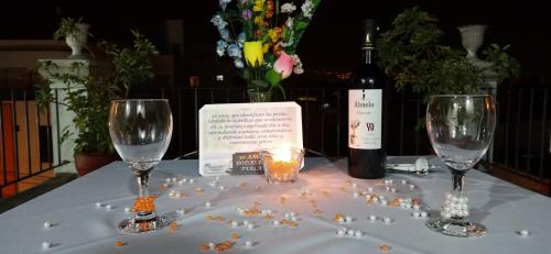 a table with two wine glasses and a bottle of wine at Hotel Mutua FAP in Arequipa