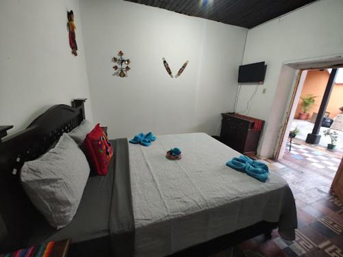 Un dormitorio con una cama con toallas azules. en La Merced en Antigua Guatemala