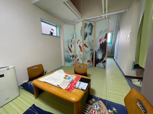 a small room with a table and chairs and a painting at 平安旅馆和风 in Tokyo