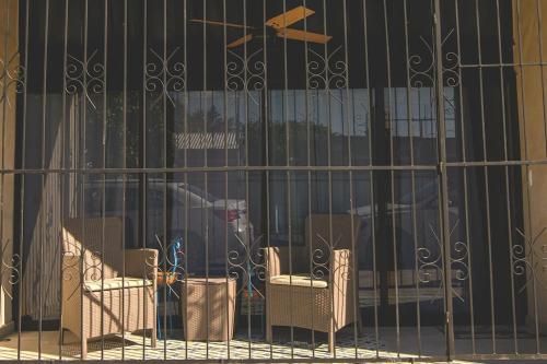 a wrought iron fence with chairs in front of a building at Departamento Dakota in Chetumal