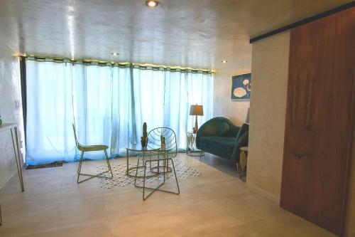 a living room with two chairs and a couch at Departamento Dakota in Chetumal