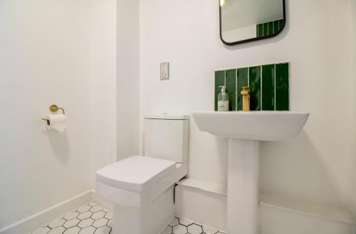 een witte badkamer met een toilet en een wastafel bij Newcastle City Apartments - FREE Parking Baltic Quay in Gateshead