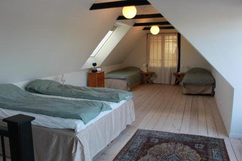 a attic bedroom with two beds and a rug at Bjerred B&B in Bjärred