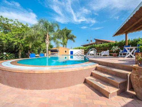 a swimming pool with a brick wall next to a brick patio at Villa Candiano in Sampieri