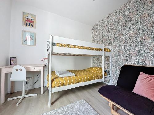 une chambre avec deux lits superposés et un bureau dans l'établissement Appartement spacieux 2 chambres proche mer, à La Grande Motte