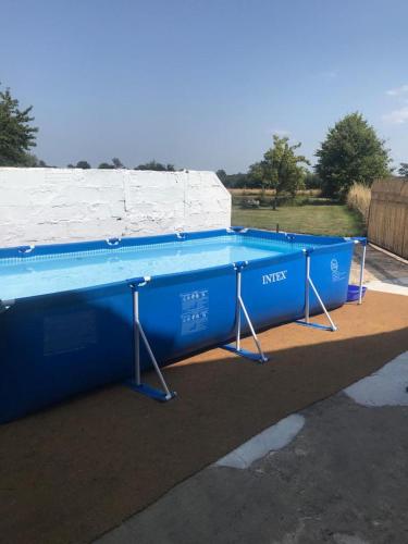 une grande piscine bleue dans un parking dans l'établissement Private Lake - Pool - Tour de France Route, à Bommiers