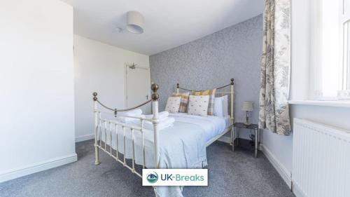 a bedroom with a bed in a white room at Pet-friendly holiday home in Egremont