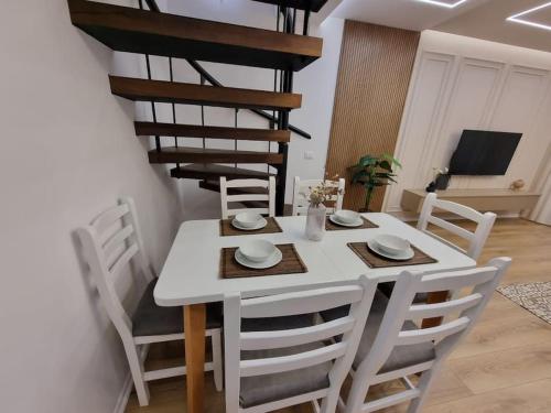 a dining room with a white table and chairs at Central Continental Apartment in Tirana