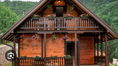 a log cabin with flower boxes on the balcony at Brvnara Sofiana in Bajina Bašta