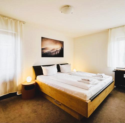 Ferienwohnung Lotti + Hochschwarzwald Card في تيتيسي نيوستادت: غرفة نوم بسرير كبير مع اطار خشبي