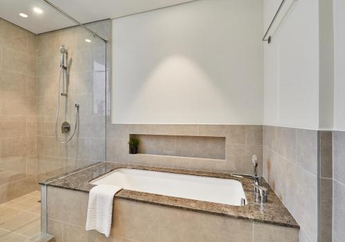 La salle de bains est pourvue d'une baignoire et d'une douche. dans l'établissement Majestic Forte2 17th- Burj khalifa & Fountain view, à Dubaï