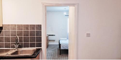uma cozinha com um lavatório e um quarto com uma mesa em Cozy 1 Bedroom Flat Nr Nottingham em Nottingham