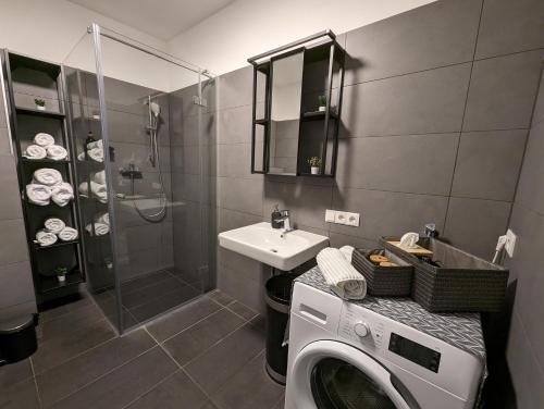 a bathroom with a washing machine and a sink at Lend City Apartment Family keyless entry in Graz