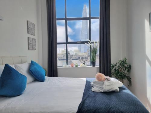a bedroom with a bed with a window and a teddy bear at Shard View Apartments in London