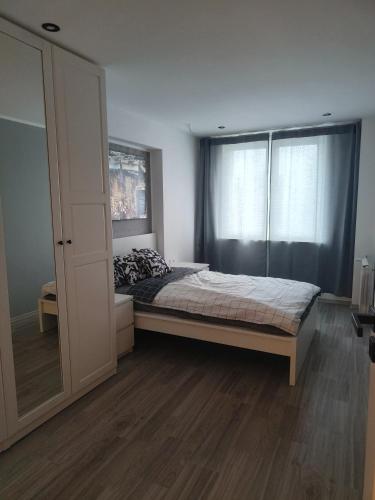 a bedroom with a bed and a large window at Mieszkanie w centrum Tarnowa 2.0 in Tarnów