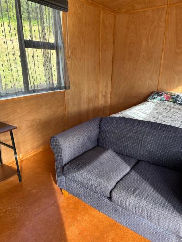 kanapę siedzącą w pokoju z oknem w obiekcie The River Shack w mieście Nelson